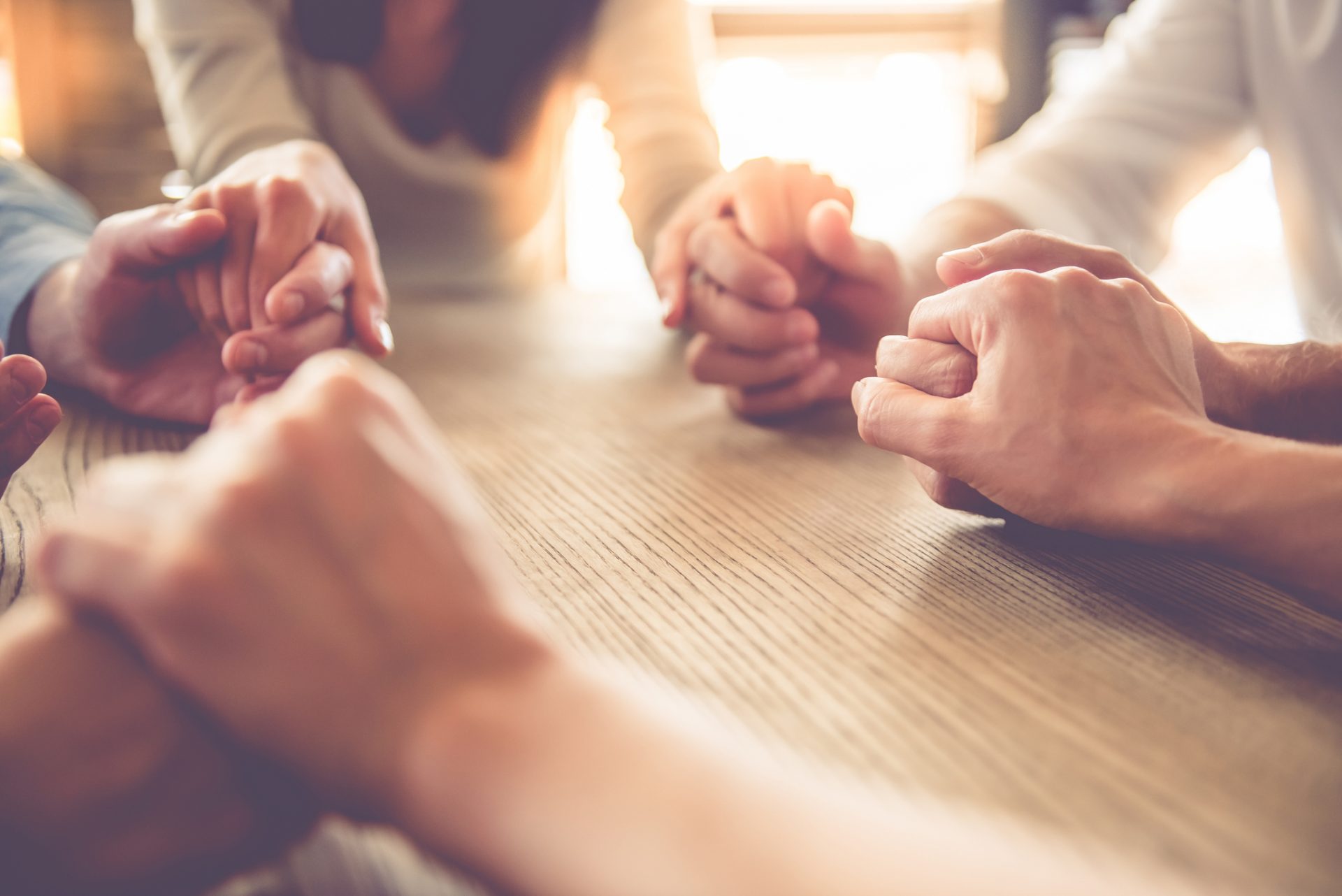 Group of people holding hands at a table