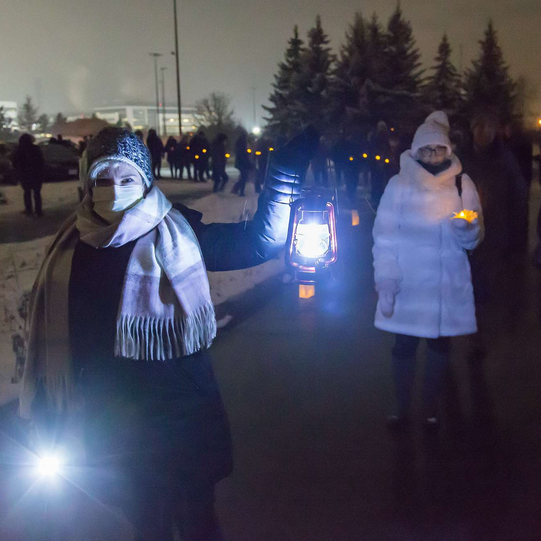Instagram 2 A woman with a lantern lights the way for others walking towards The Gies Family Centre.