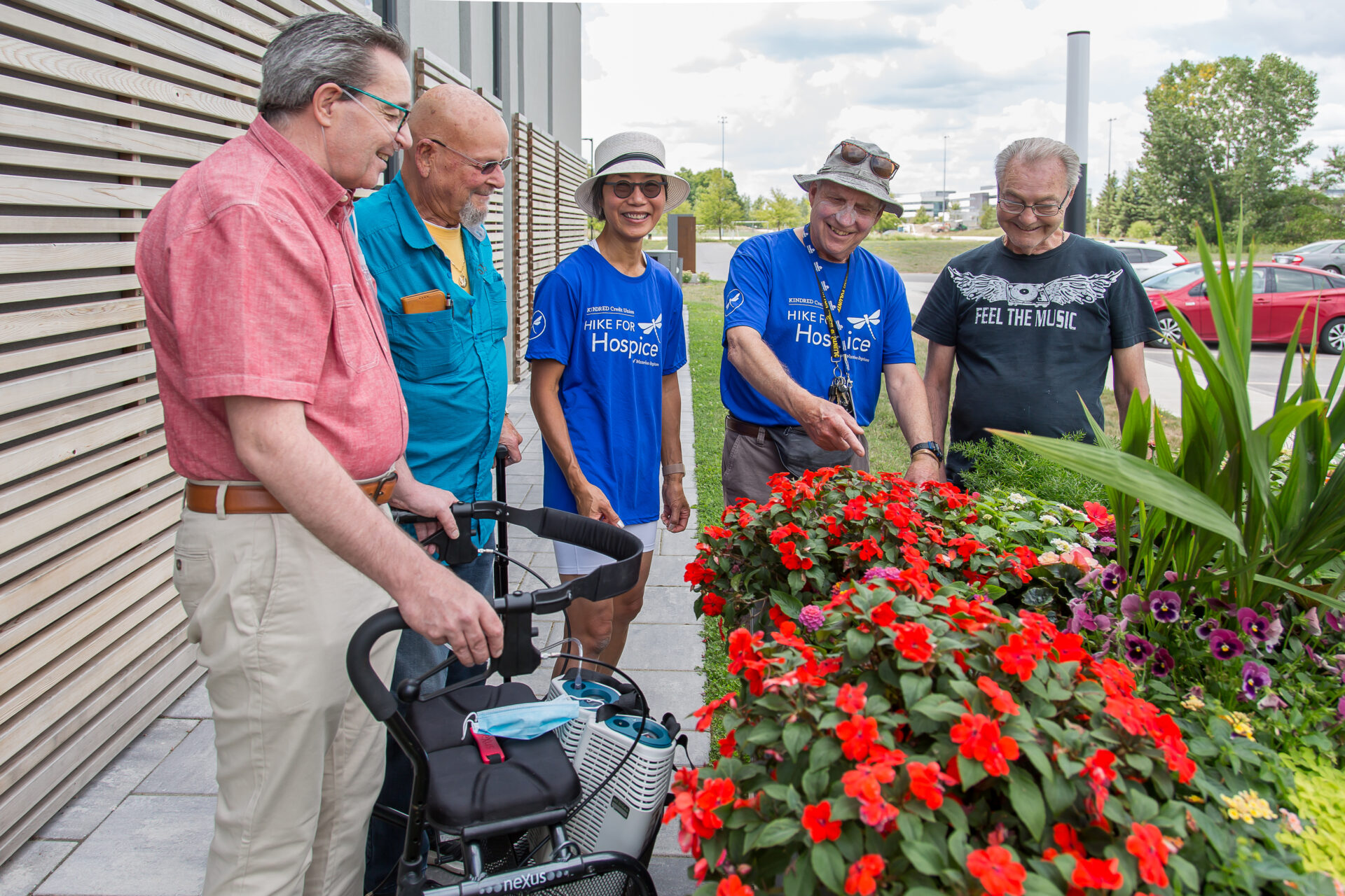 A group of people standing around flower beds