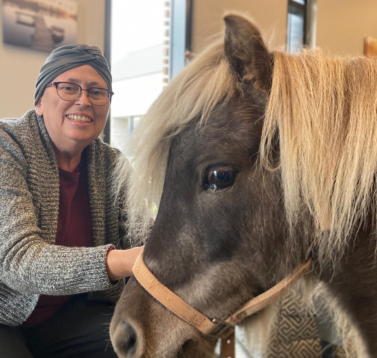 A woman pets a pony