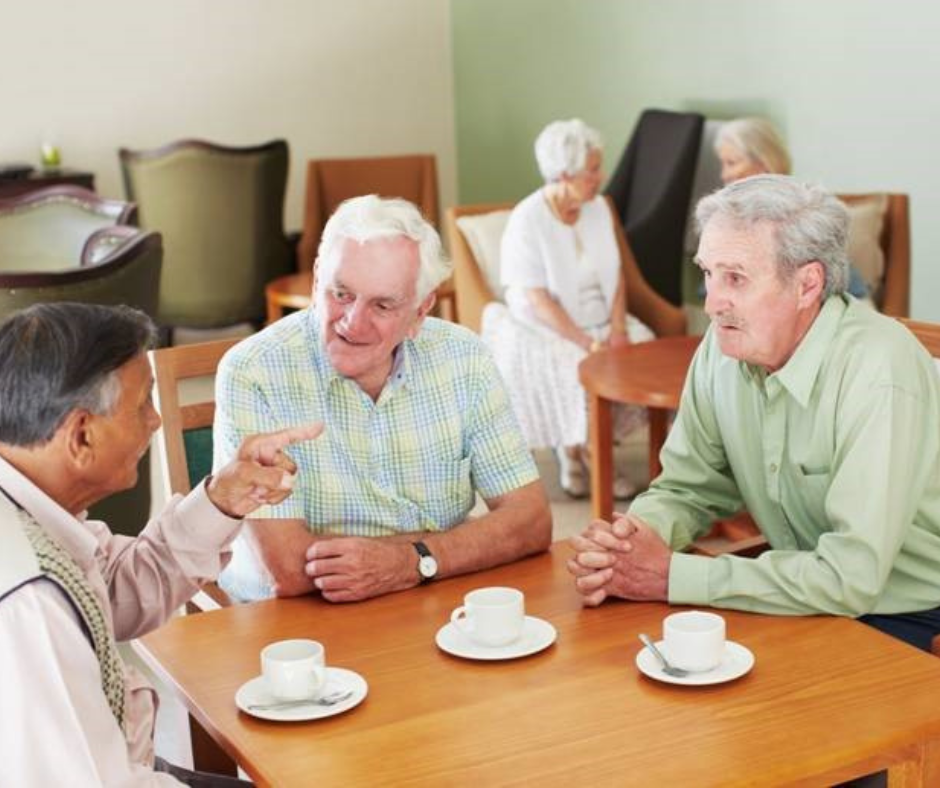 Website - Group of men talking Three men sit at a table talking, and drinking coffee