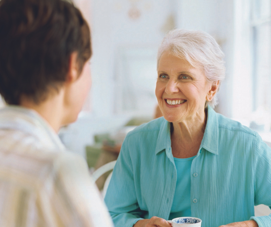 Two women talking to each other and drinking tea