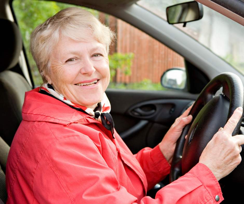 A woman is seated behind a steering wheel in a car