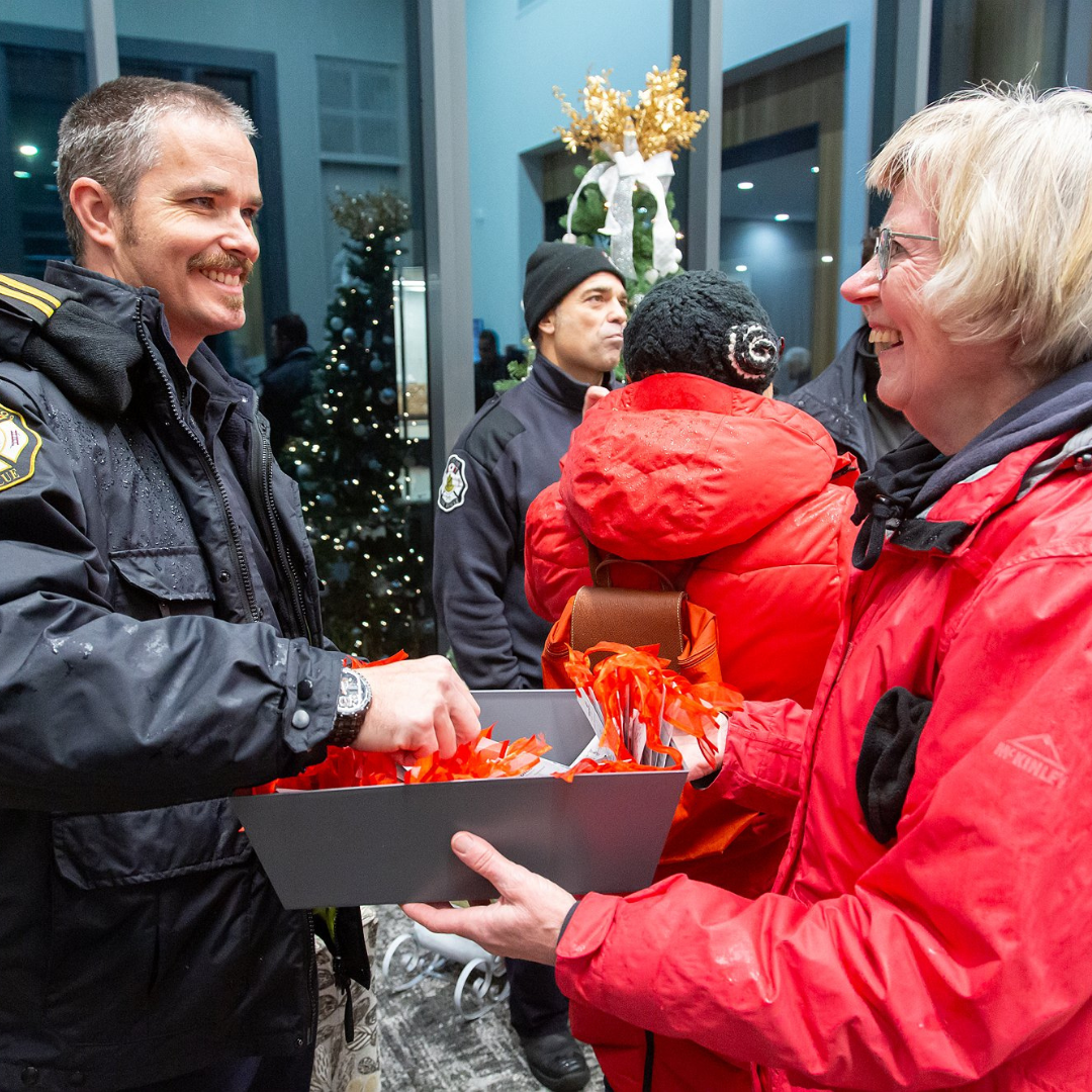 Lynn hands out bookmarks for a Waterloo Fire Rescue member.